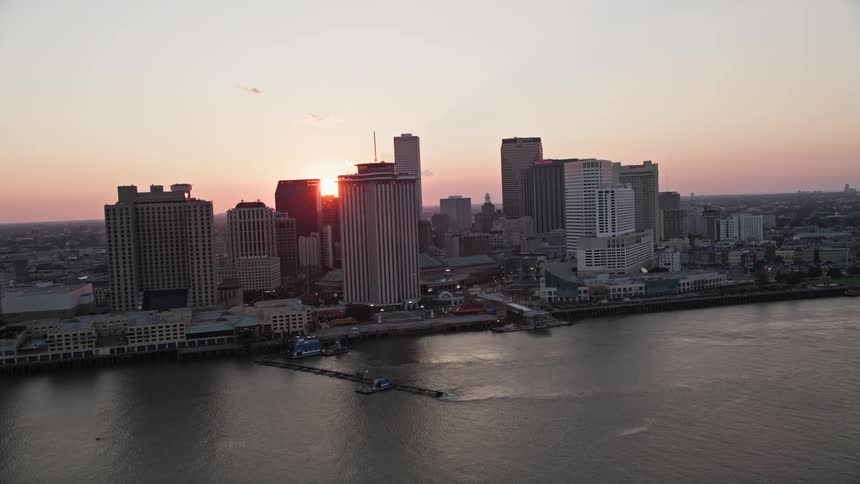 Aerial panorama of a metropolis with large buildings by the sea with the red sun on the horizon