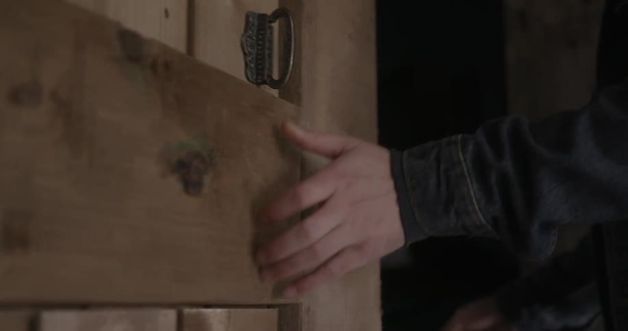 A person opens a barn door and enters