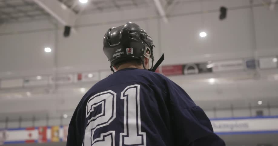 A hockey player skates onto the ice in an arena