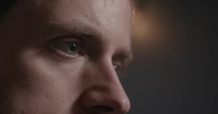 A light-eyed man stares at something