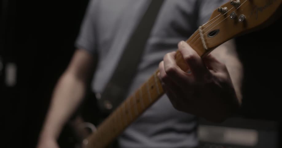 A guitarist strums on a fender telecaster guitar