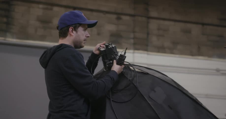 A man is carrying a large item with wires