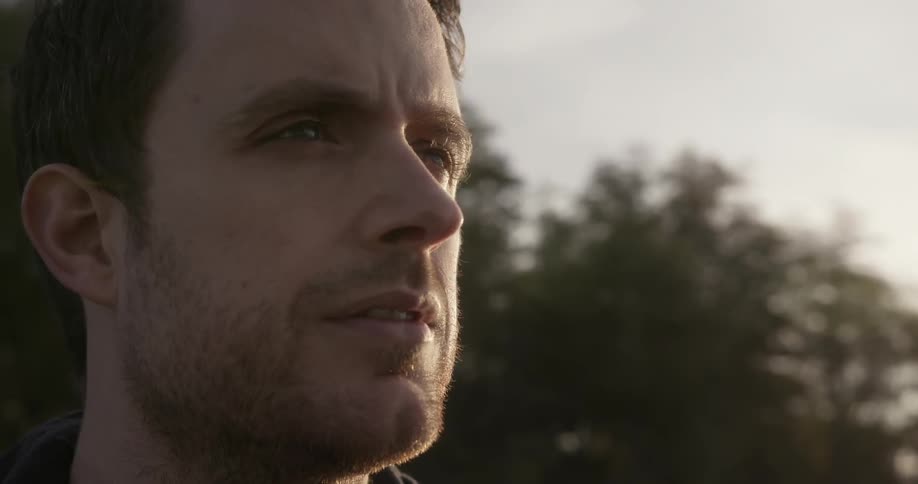 A man looks towards the distance while standing outside