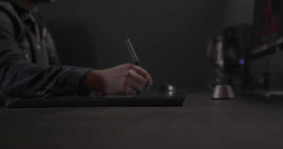 Person sitting at a table with a writing instrument