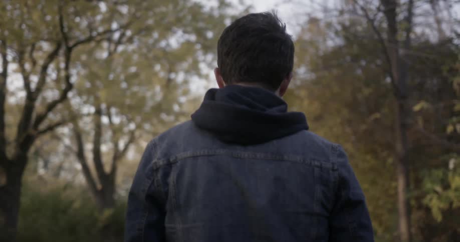 A man is walking in a wooded area