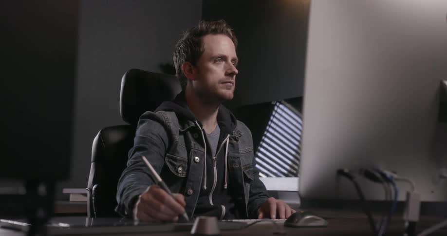 A man sits at a desk working on a computer
