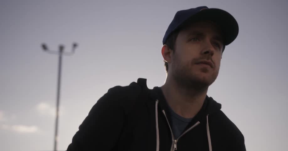A man in a cap walks outside