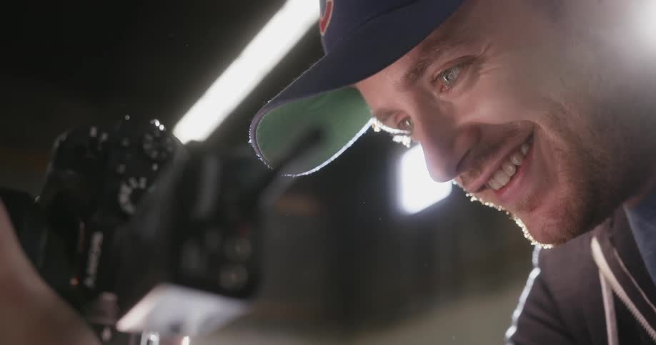 A photographer smiles as he peers into his camera