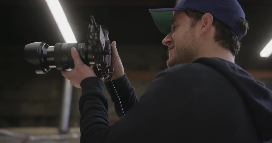 A photographer smiles and takes a photograph