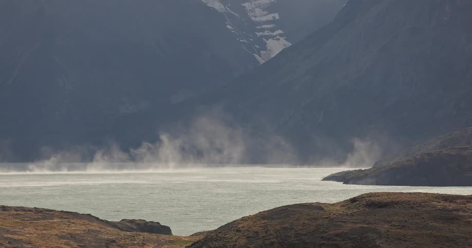 strong winds moving gusts of spray over a lake