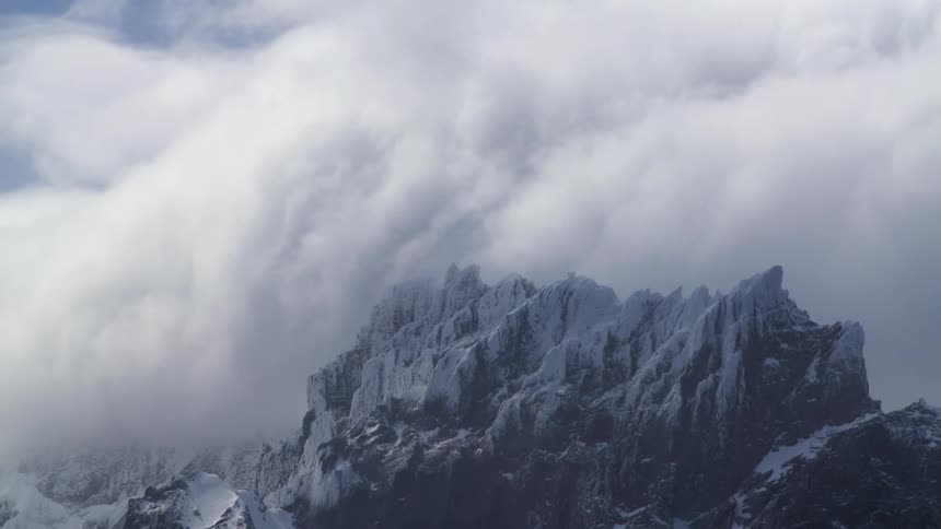 Aerial of a snowcovered mountain range during a blizzard