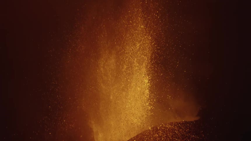 A volcanic eruption with bright lava and ash against a dark background