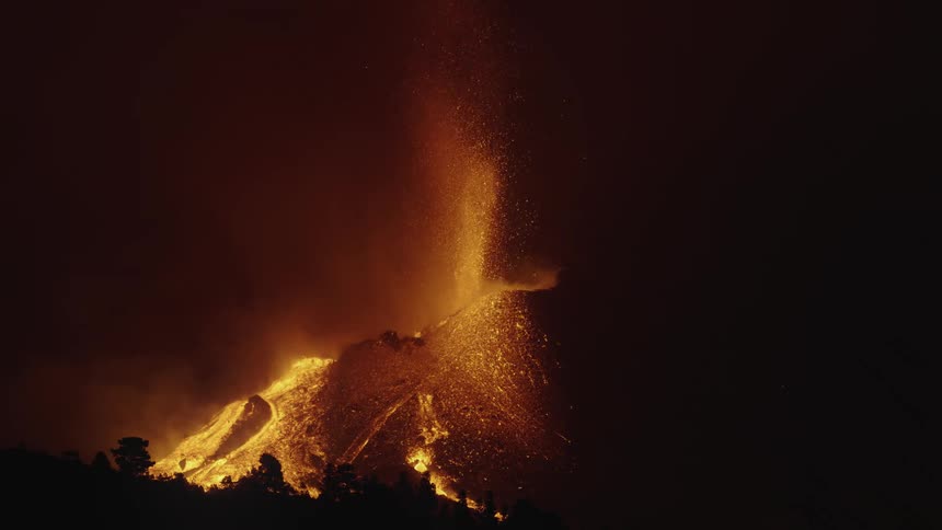 A volcano erupts at night