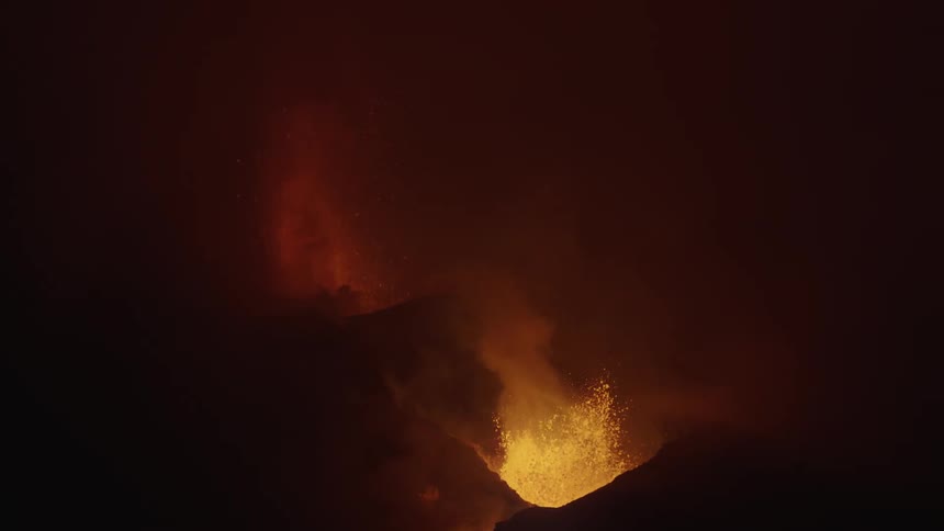 A large volcano erupts at night