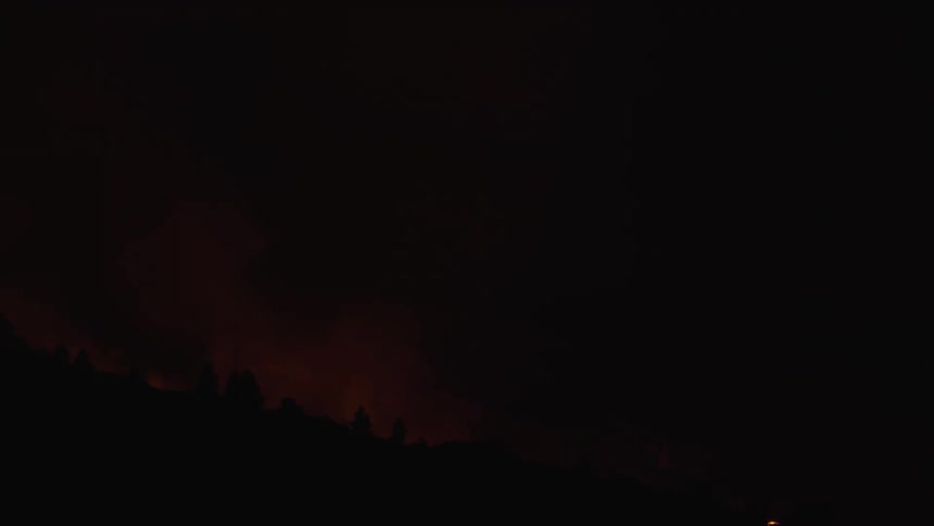 A volcano erupts at night