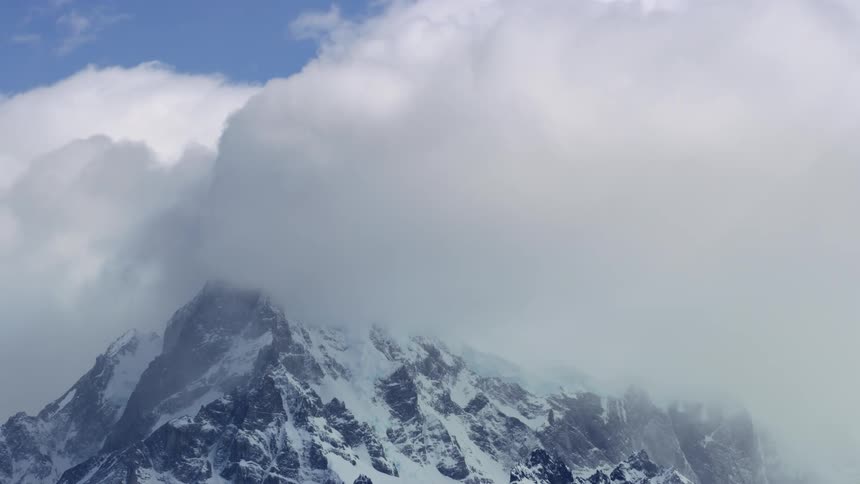 Aerial of a snowcovered mountain with cloudy sky