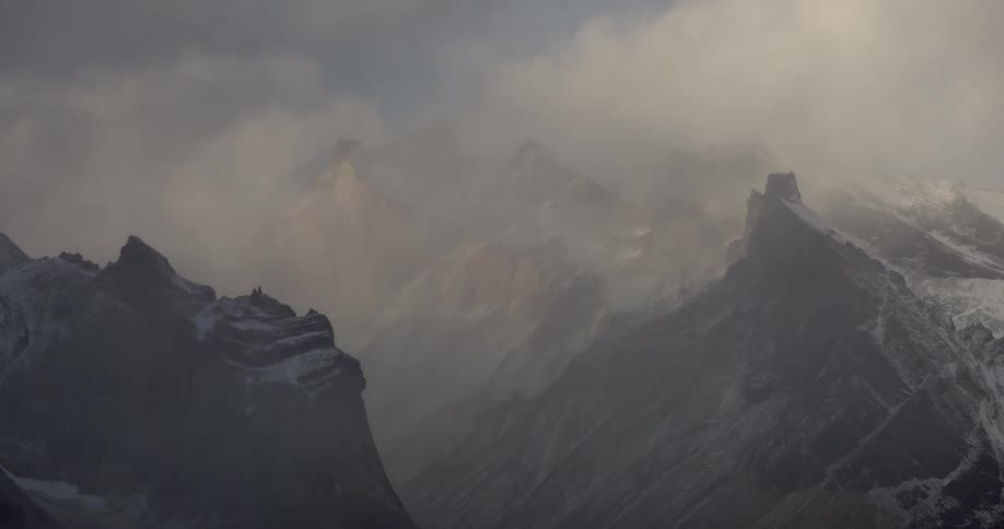 A misty landscape of a mountain range surrounded by a thick fog