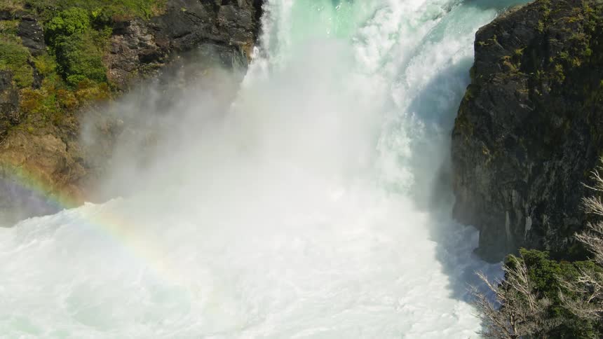 A river leads to a massive waterfall that sends water crashing below it with great force