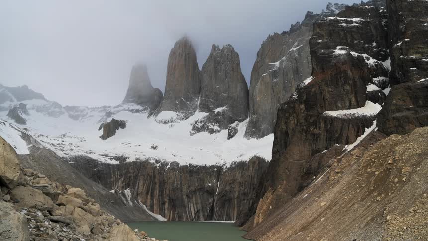A lake sits by huge mountains
