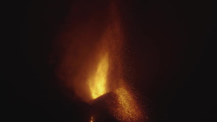Orange volcano lava flames shooting up from mountain at night
