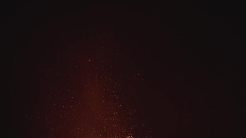 A view of some lava erupting from a volcano at night