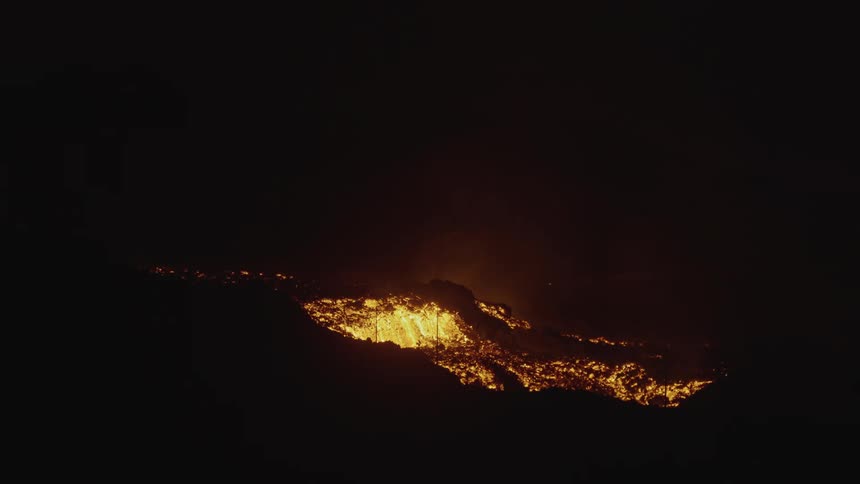 A volcanic eruption with bright lava and ash against a dark background