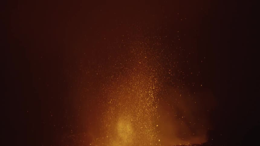 A volcanic eruption with bright lava and ash against a dark background