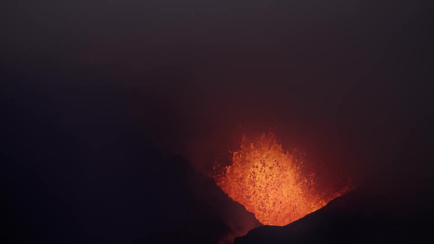 Lava gushing out of a volcano at night