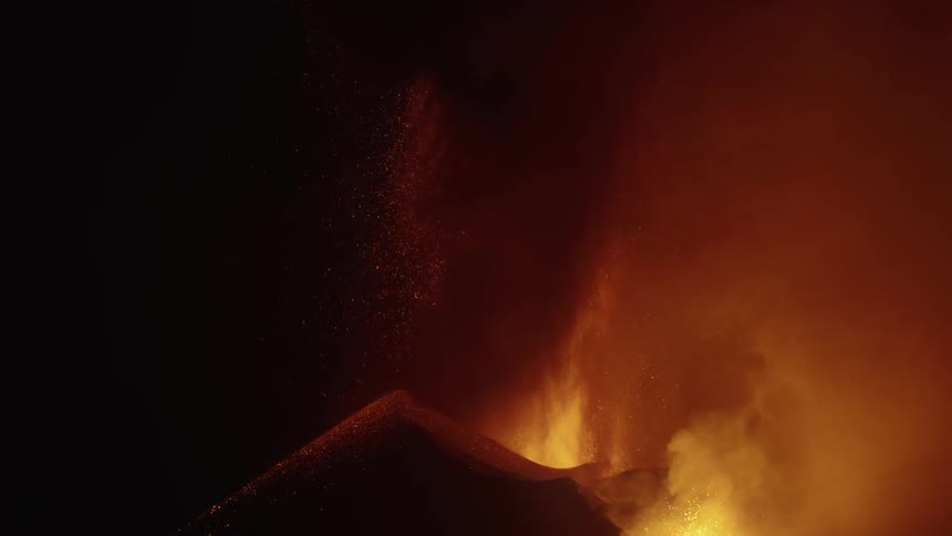 A volcanic eruption with bright lava and ash against a dark background