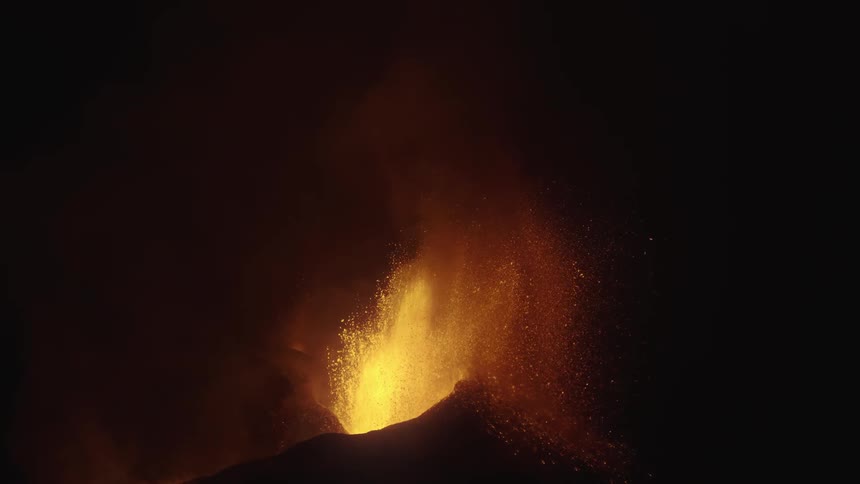 An erupting volcano releasing a lot of lava into the air in one night