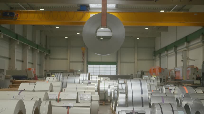 A hanging cylindrical object is in a room full of similar objects on the floor