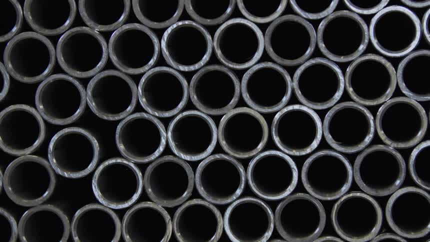 Large number of stacked metal pipes form irregular pattern of circles