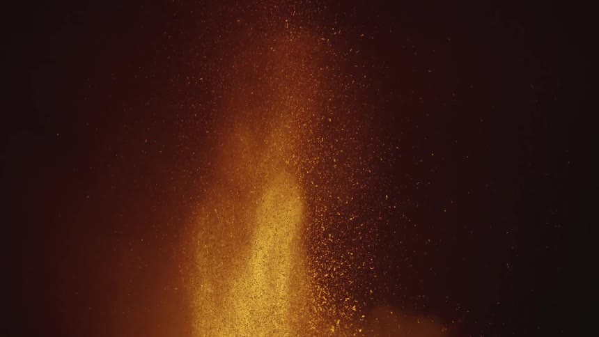 Lava spurts into the night sky contrasting with the darkness
