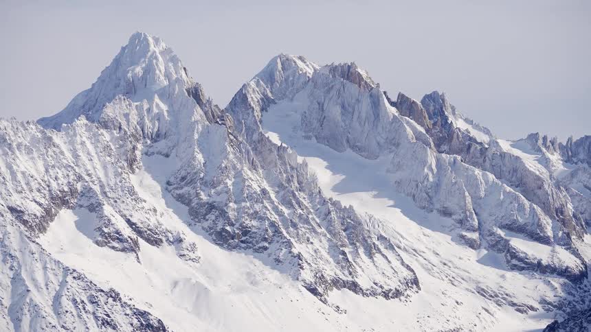 Aerial of a snowcovered mountain on a sunny day
