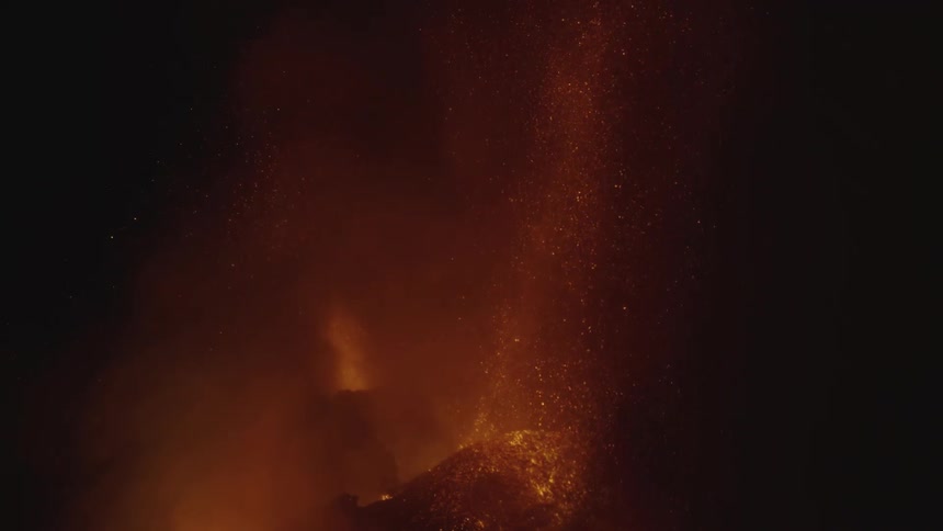 A volcanic eruption with bright lava and ash against a dark background