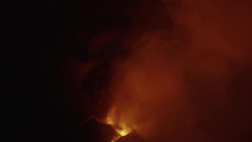 A volcano emits lava and tremendous clouds of smoke