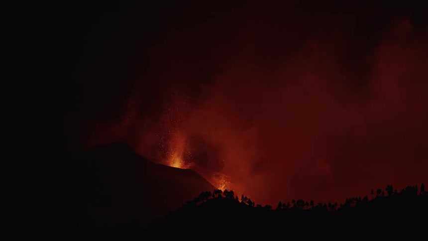 An eruption of a volcano spewing lava and sparks upward