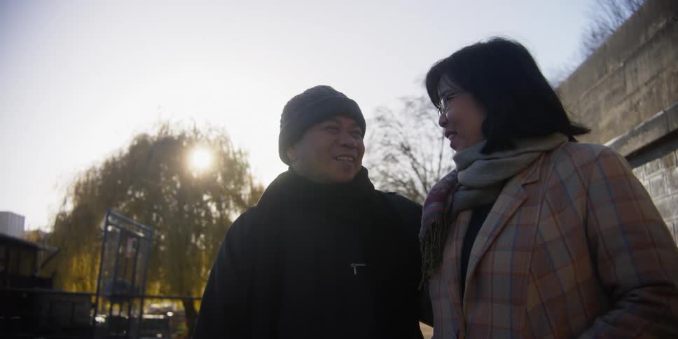 Smiling couple together talking side by side in an outdoor environment