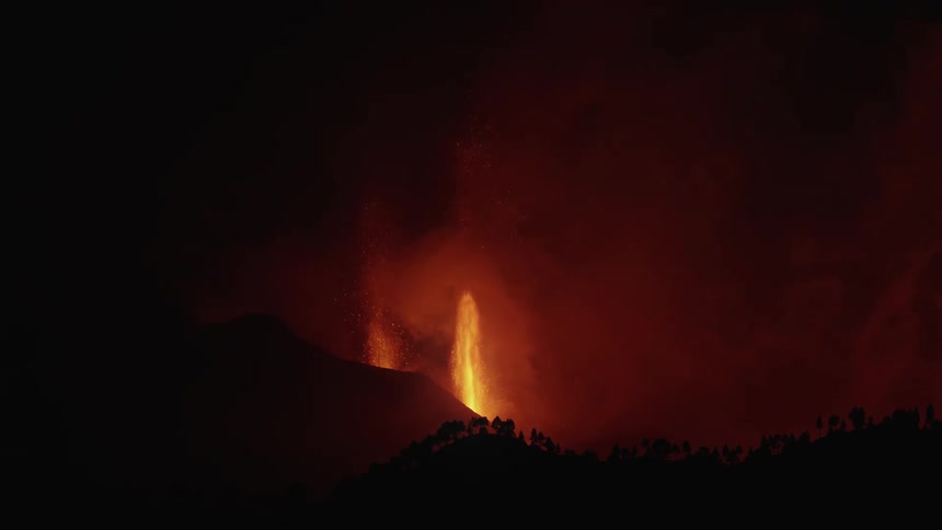 A volcano erupts with boiling lava lighting up the night