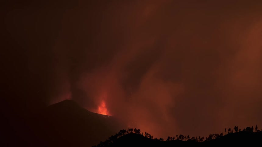 A timelapse of a volcano and forest fire at night