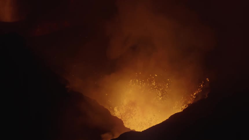 A volcano erupting at night with lava spraying everywhere