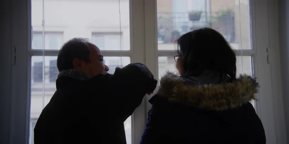 Couple looking at the city from an apartment window