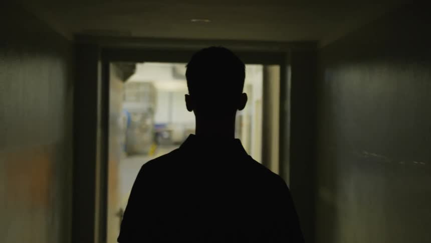 A man walking through the halls of a company during the day
