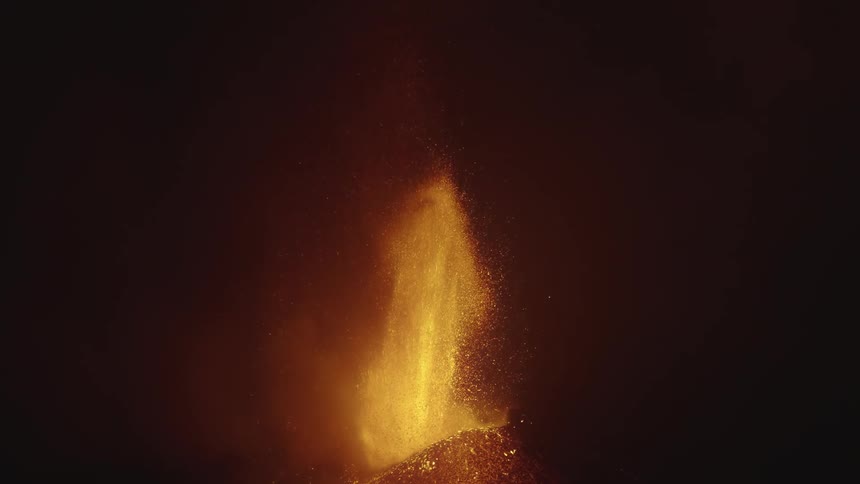 A volcanic eruption with bright lava and ash against a dark background
