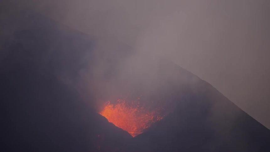 Aerial closeup of a volcano erupting at dusk