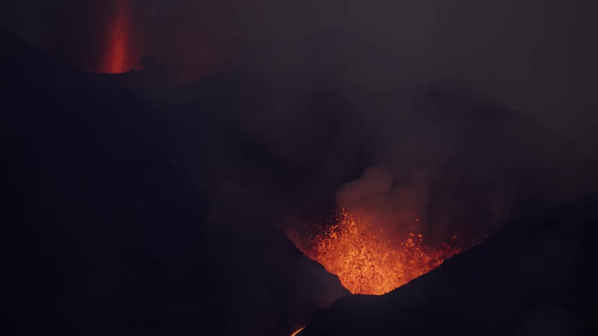 Lava erupts from two holes in a mountain