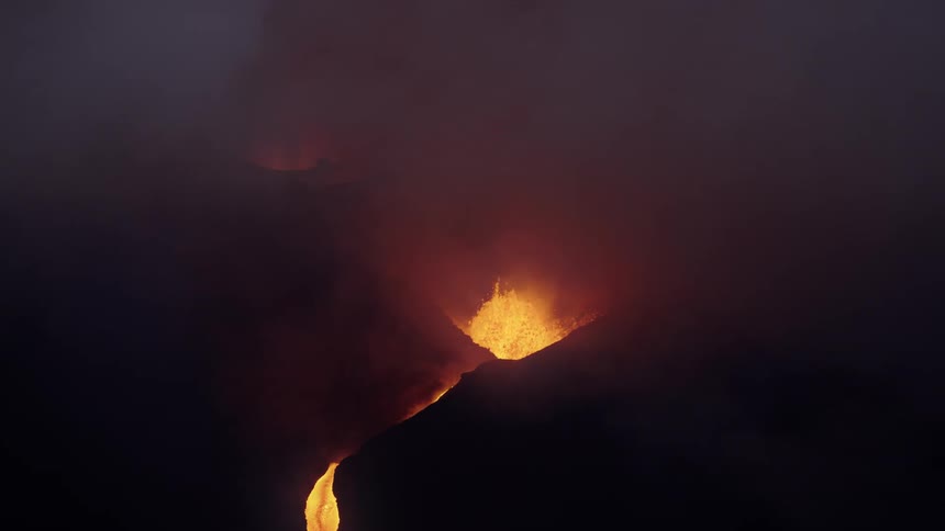 A volcano erupting and expelling magma and leaving smoke in the environment