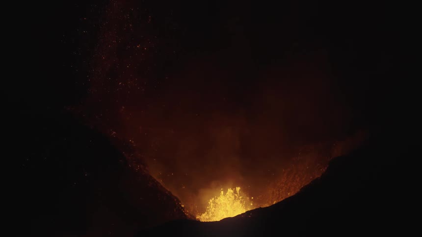 A volcano is erupting at night