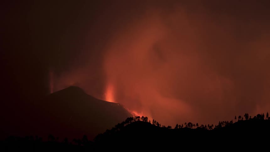 A mountain on fire and releasing lots of smoke one night