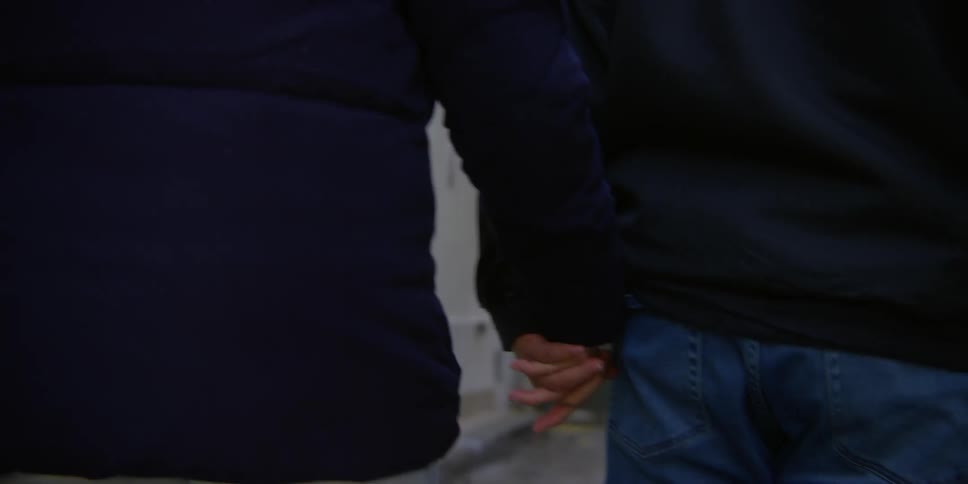 Two people walking outdoors holding hands